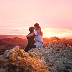 Une mère, son enfant dans les bras, est assise au sommet d'une montagne et contemple le coucher de soleil Une mère, son enfant dans les bras, est assise au sommet d'une montagne et contemple le coucher de soleil