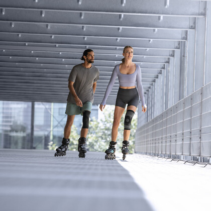Orthopaedics A man and a woman wearing knee braces are rollerblading in a garage.