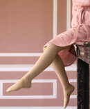 7. Lifestyle Bild Juzo Soft Frau mit Juzo Soft Sesam sitzt auf einem Kaminsims