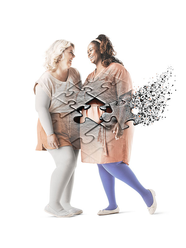 Zwei Frauen im lachen gemeinsam. Sie tragen Kompressionsstrümpfe. Im Vordergrund Puzzleteile, die ineinander gelegt werden. Zwei Frauen im lachen gemeinsam. Sie tragen Kompressionsstrümpfe. Im Vordergrund Puzzleteile, die ineinander gelegt werden.