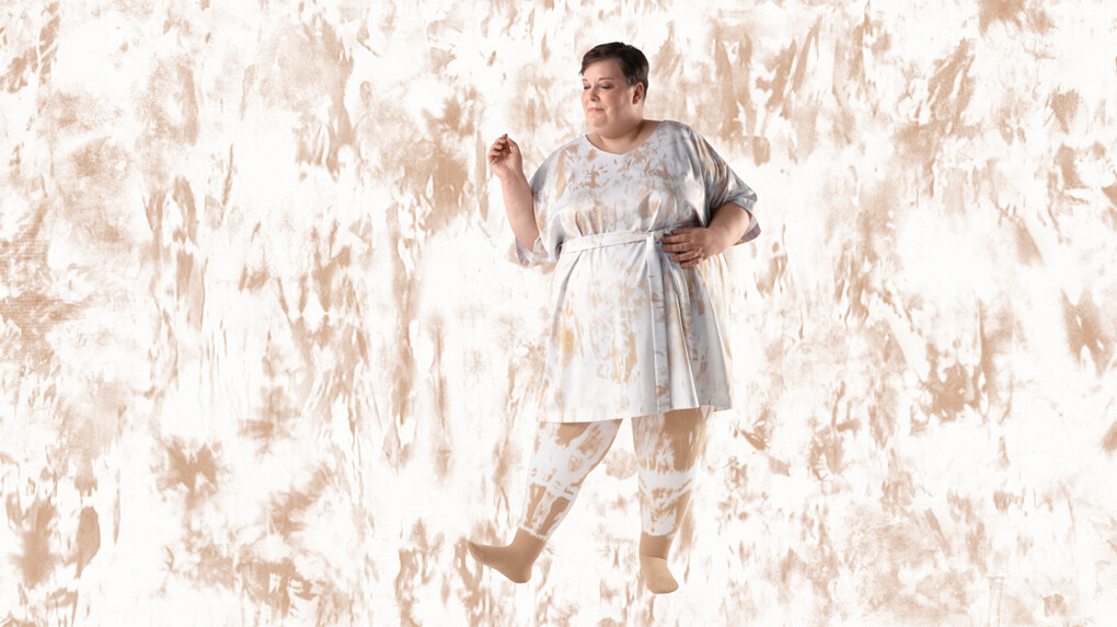 A woman wearing batik-patterned compression stockings against a batik-patterned background